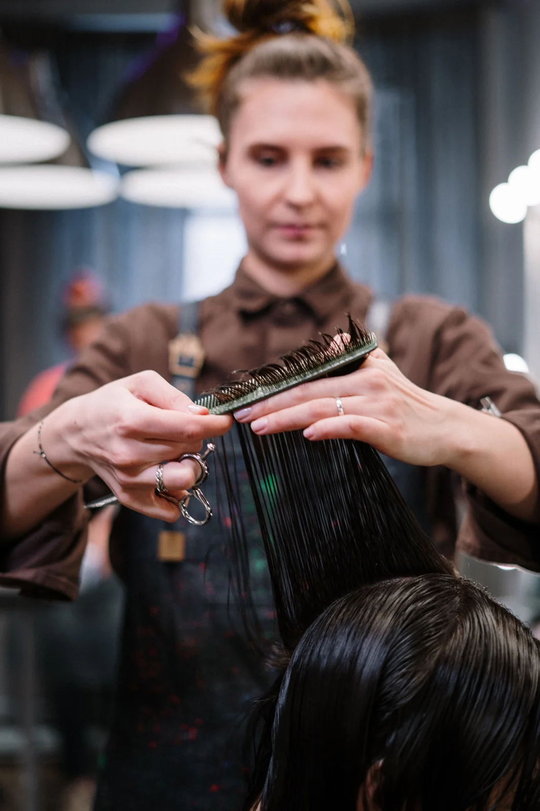 Hair stylist carefully cutting a client’s hair